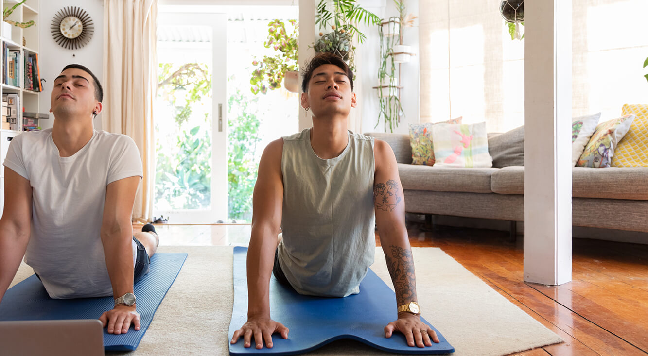 Gay couple doing yoga at home